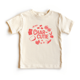 Chunky Deli product image: Toddler tee in 100% cotton, short sleeve, nude color. Features a stylized graphic with the text "Char-Cutie" surrounded by vibrant illustrations of crackers, cheese, berries, olives, figs, and goldfish. The print is an orangey-p
