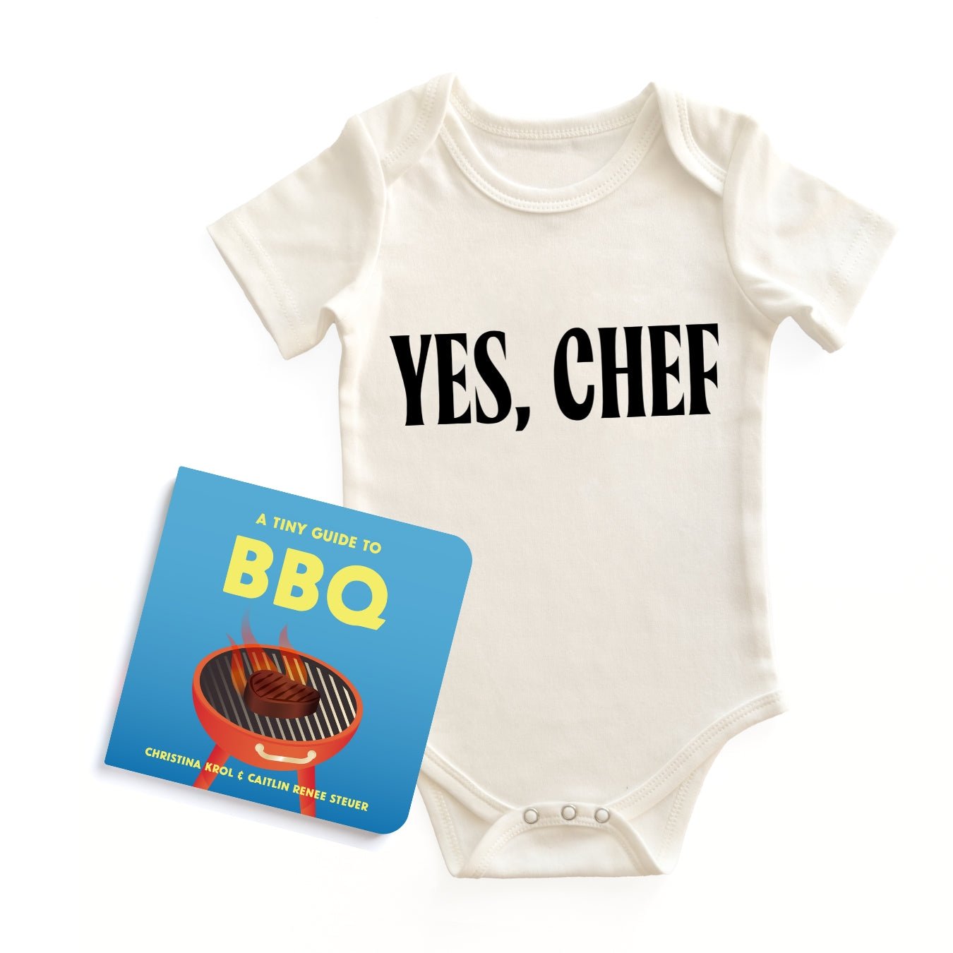 Chunky Deli "Yes, Chef Starter Pack" featuring a white, 100% cotton, short sleeve baby bodysuit with black "YES, CHEF" text, accompanied by the "A Tiny Guide to BBQ" board book by Christina Krol & Caitlin Renee Steuer, all on a white background.