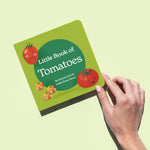 Hand holds up "Little Book of Tomatoes," a square, green children's book above a green background. The cover features three happy tomatoes with faces.