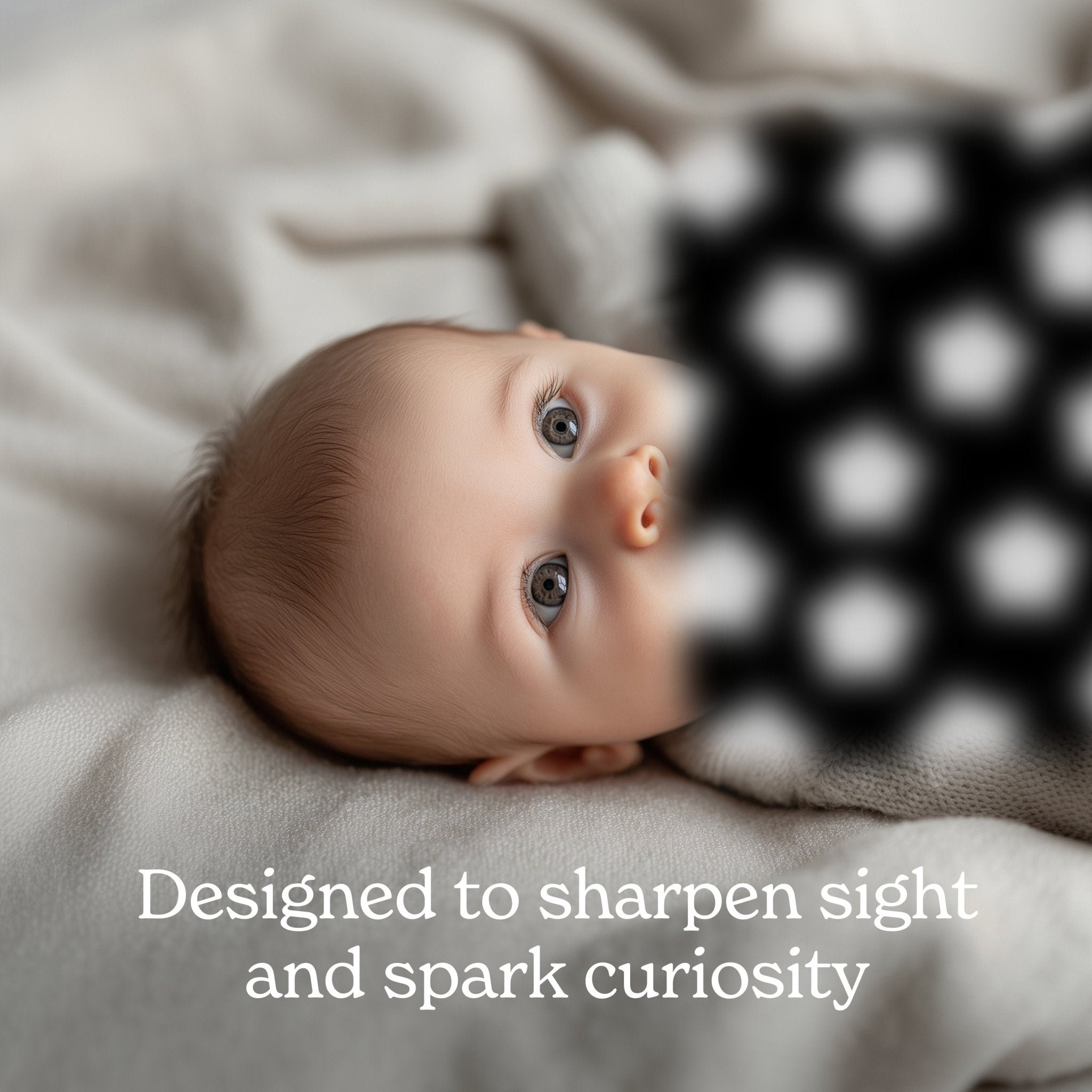Newborn baby with big gray eyes stares at a blurry, black and white pattern with the caption: “Designed to sharpen sight and spark curiosity.”