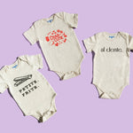 Chunky Deli product image: Three natural-colored bodysuits fanned out on a purple background, each displaying a different graphic design: "Petite Frite," "Charcutie," and "Al Dente."