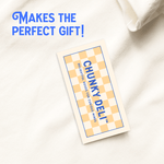 Chunky Deli hang tag attached to apparel, reading "Makes the perfect gift!" and featuring the brand name, trademark, and slogan: "Delightful goods for curious minds." Chunky Deli display photo.