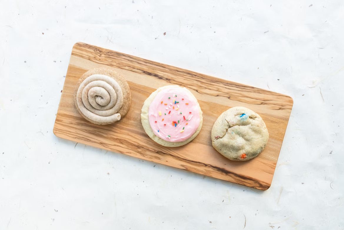 Three different cookies on a wood platter.