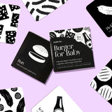 Chunky Deli Burger for Baby box surrounded by scattered high-contrast black and white art cards featuring burger ingredients.