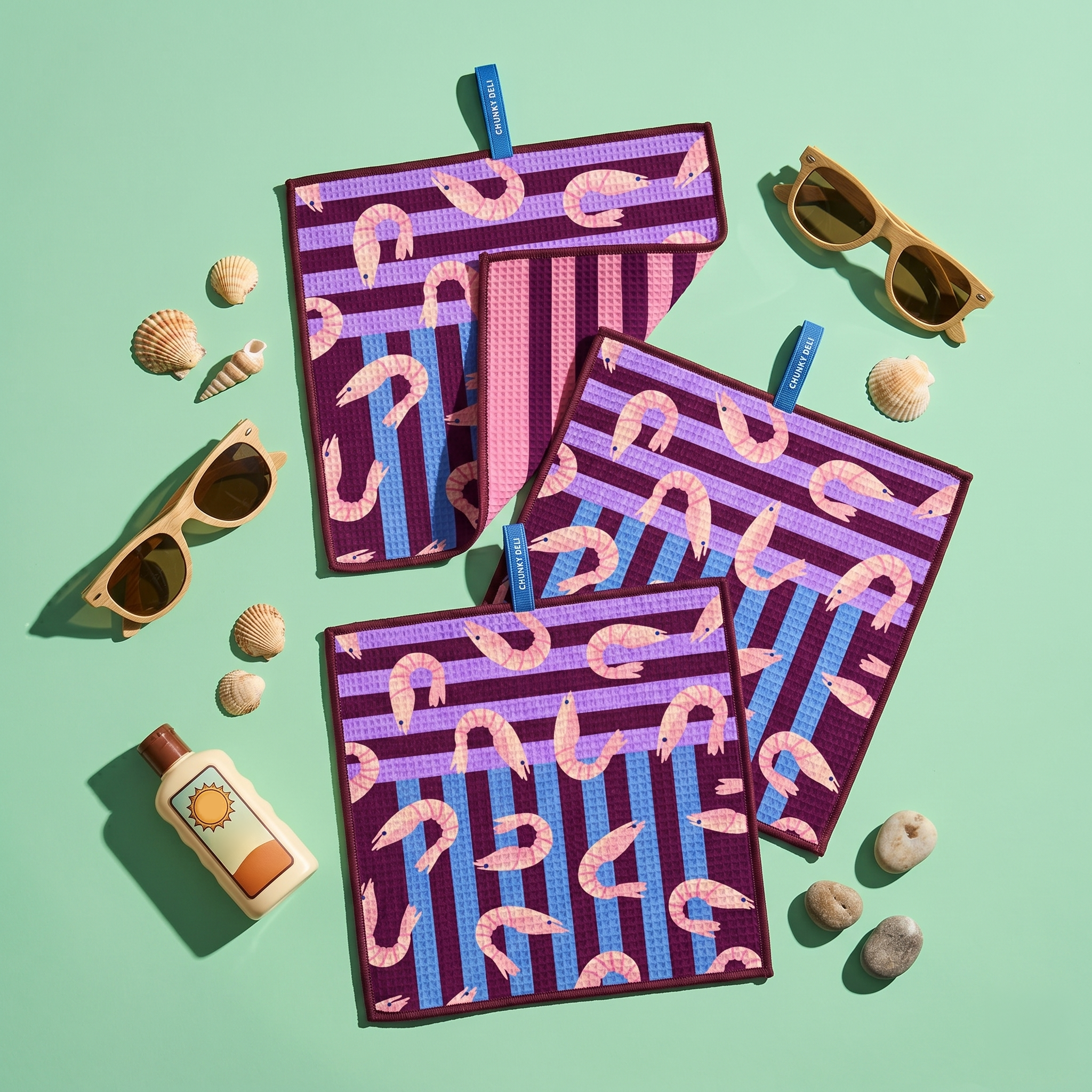 Chunky Deli product image of a set of three purple and pink patterned cleanup cloths featuring shrimp with sunglasses and a bottle on a green background
