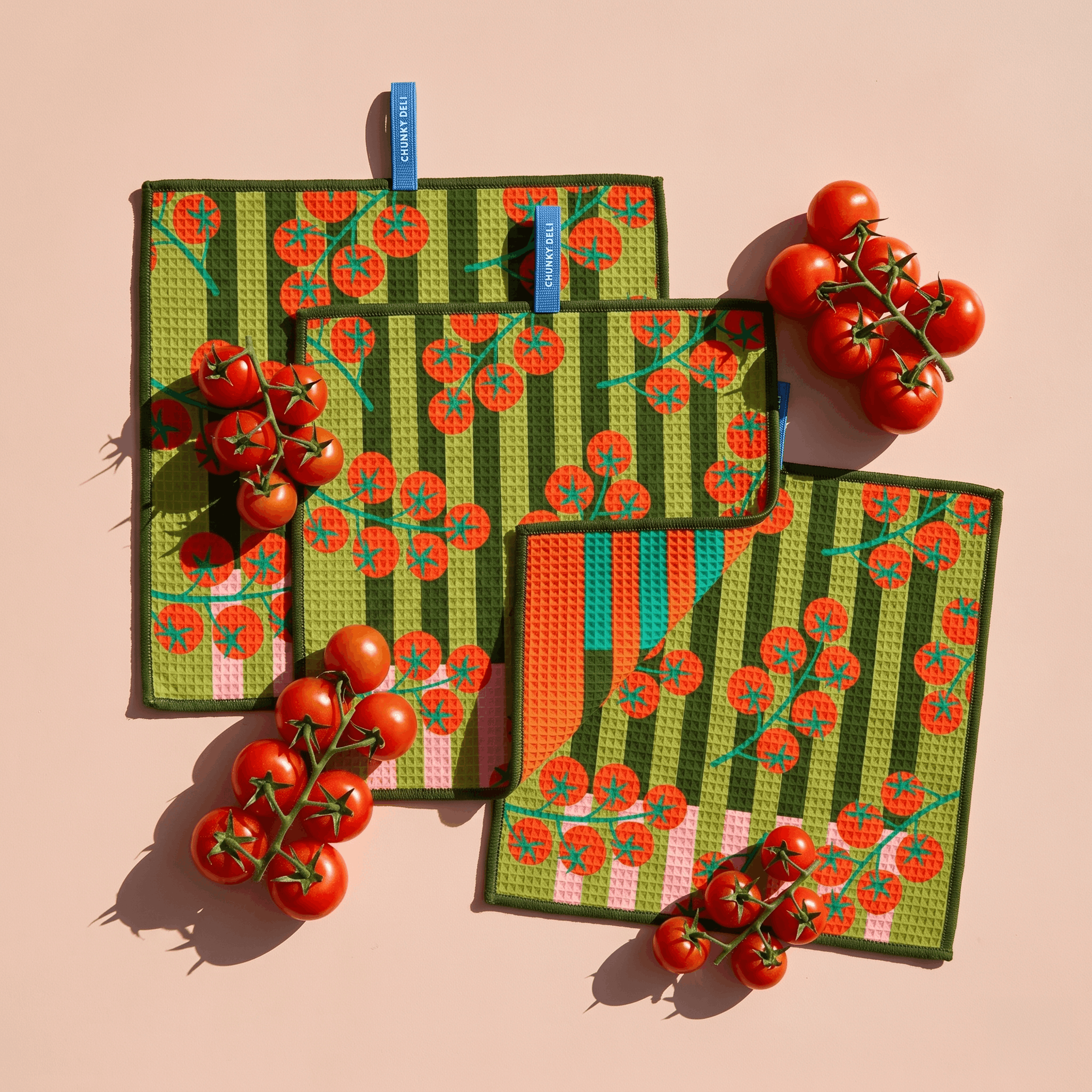 Chunky Deli product image of a set of three green cleanup cloths with red tomato pattern on a pink background