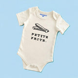 Product display image of the "Petite Frite" baby bodysuit in natural cotton, laid flat on a pastel blue background. Chunky Deli product image.