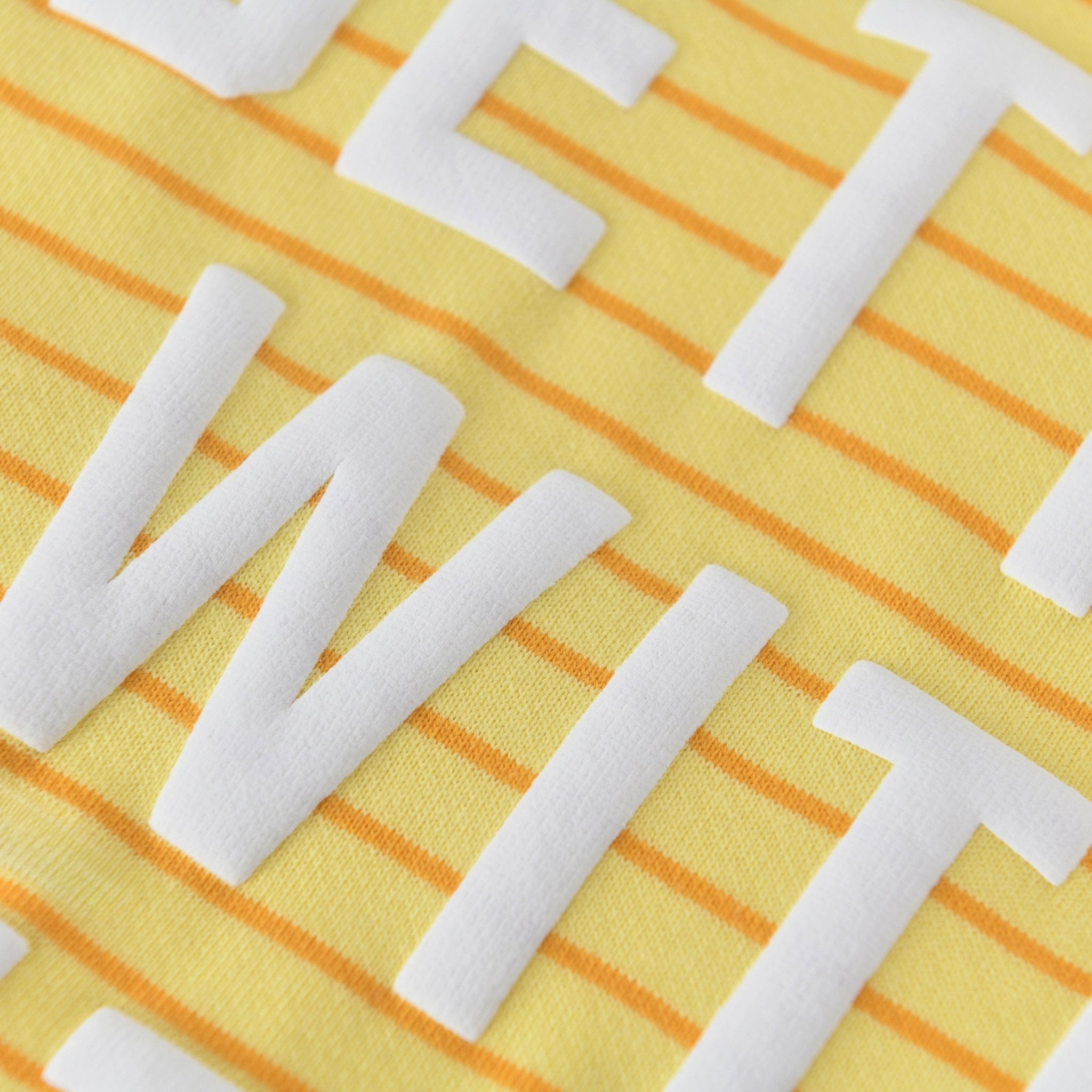 Close-up of the Better with Butter Kids Crewneck Sweater showing bright yellow fabric with white text.