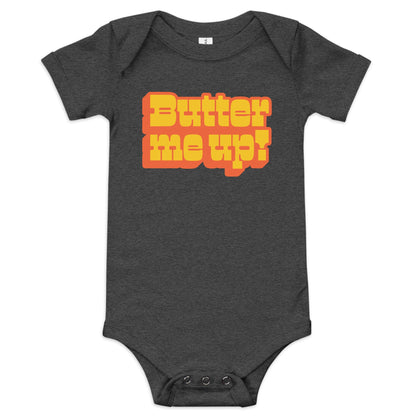 Chunky Deli product image: "Butter Me Up" onesie (100% cotton, black color) laid flat on a white background, showcasing the envelope shoulders, short sleeves, three-snap closure, and the text "Butter Me Up" printed in orange and red across the chest.