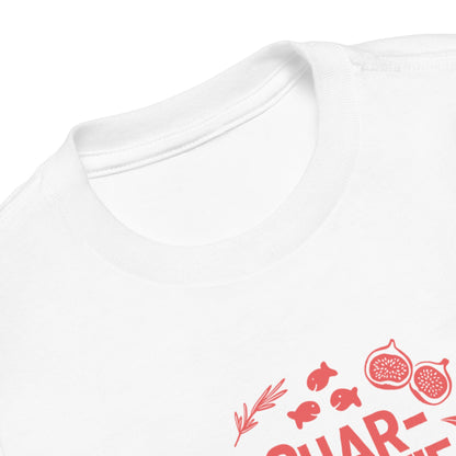Chunky Deli product image: White short-sleeved kids' and toddler t-shirt with the text "Charcutie" in orange font, surrounded by illustrations of charcuterie board foods, on the chest. This is a close up shot of the neckline.