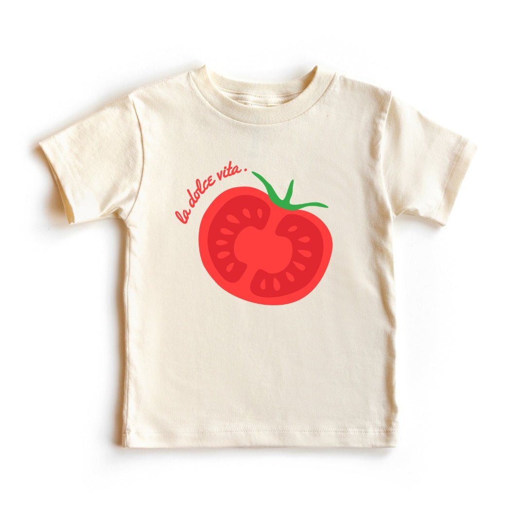 A soft white toddler t-shirt featuring a vibrant red tomato graphic and the words La Dolce Vita in elegant script. Chunky Deli Product Image