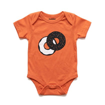 Chunky Deli Product Image: Orange baby onesie with a two tone graphic of an everything bagel with cream cheese on a white background