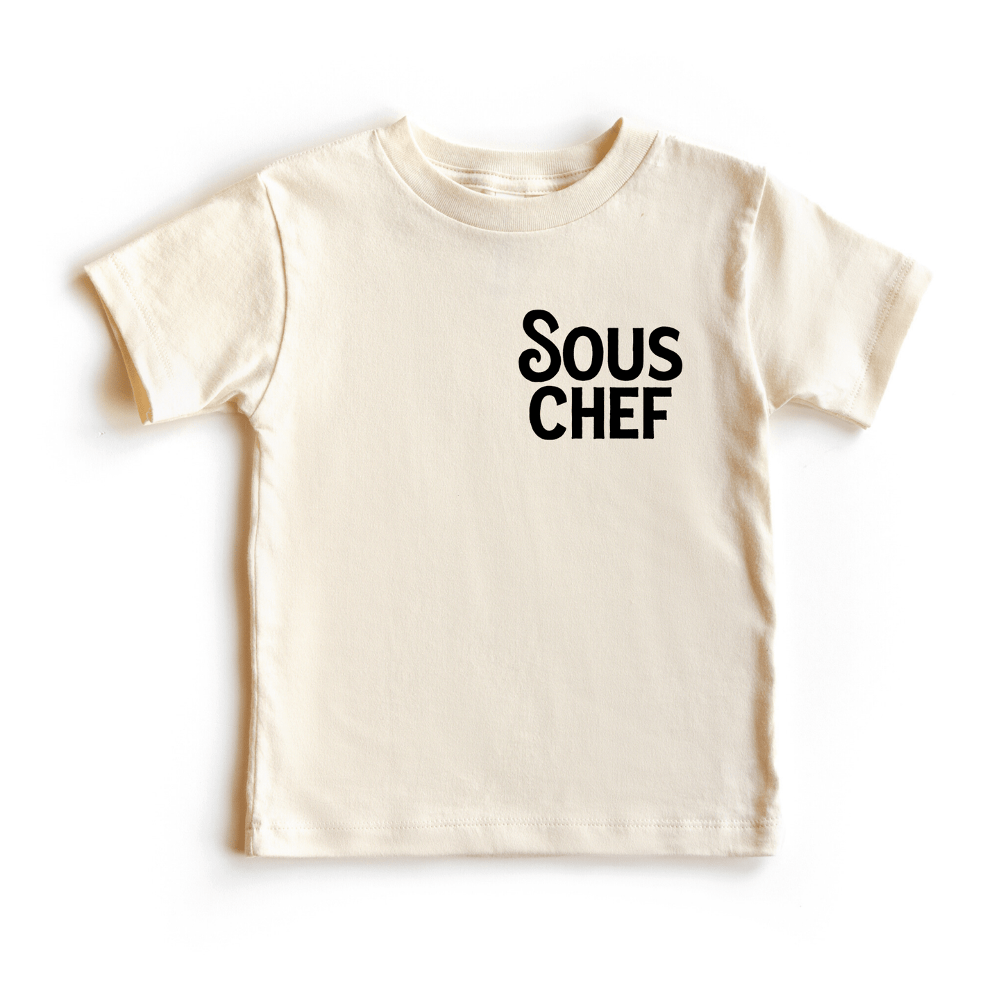 Chunky Deli product image: Toddler tee in 100% cotton, short sleeve, beige/natural color. Features printed text reading "Sous Chef" on the upper left chest, positioned like a breast pocket.