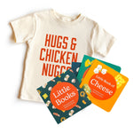 Chunky Deli "Hugs & Chicken Nuggs Starter Pack" featuring a nude, 100% cotton, short sleeve toddler tee with bold red text "HUGS & CHICKEN NUGGS", accompanied by two "Little Books" board books: "Little Book of Cheese" by Christina Sicoli & Caitlin Renee S