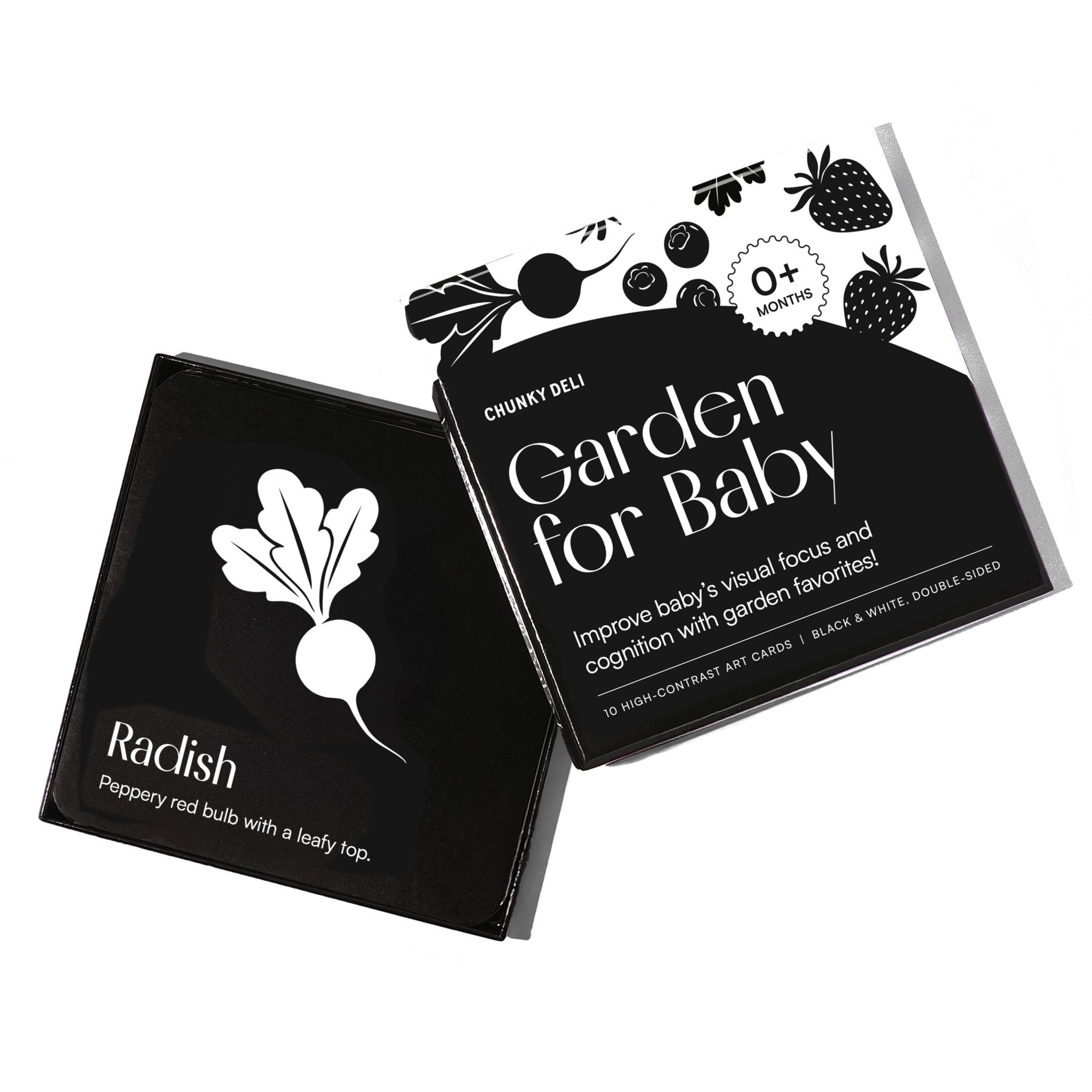 High-angle product shot of a black and white "Garden for Baby" art card set. The box is open, with a radish card resting on it.