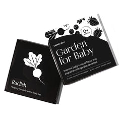  High-angle product shot of a black and white "Garden for Baby" art card set. The box is open, with a radish card resting on it.
