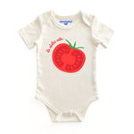 White baby onesie with red tomato graphic and text on a white background
