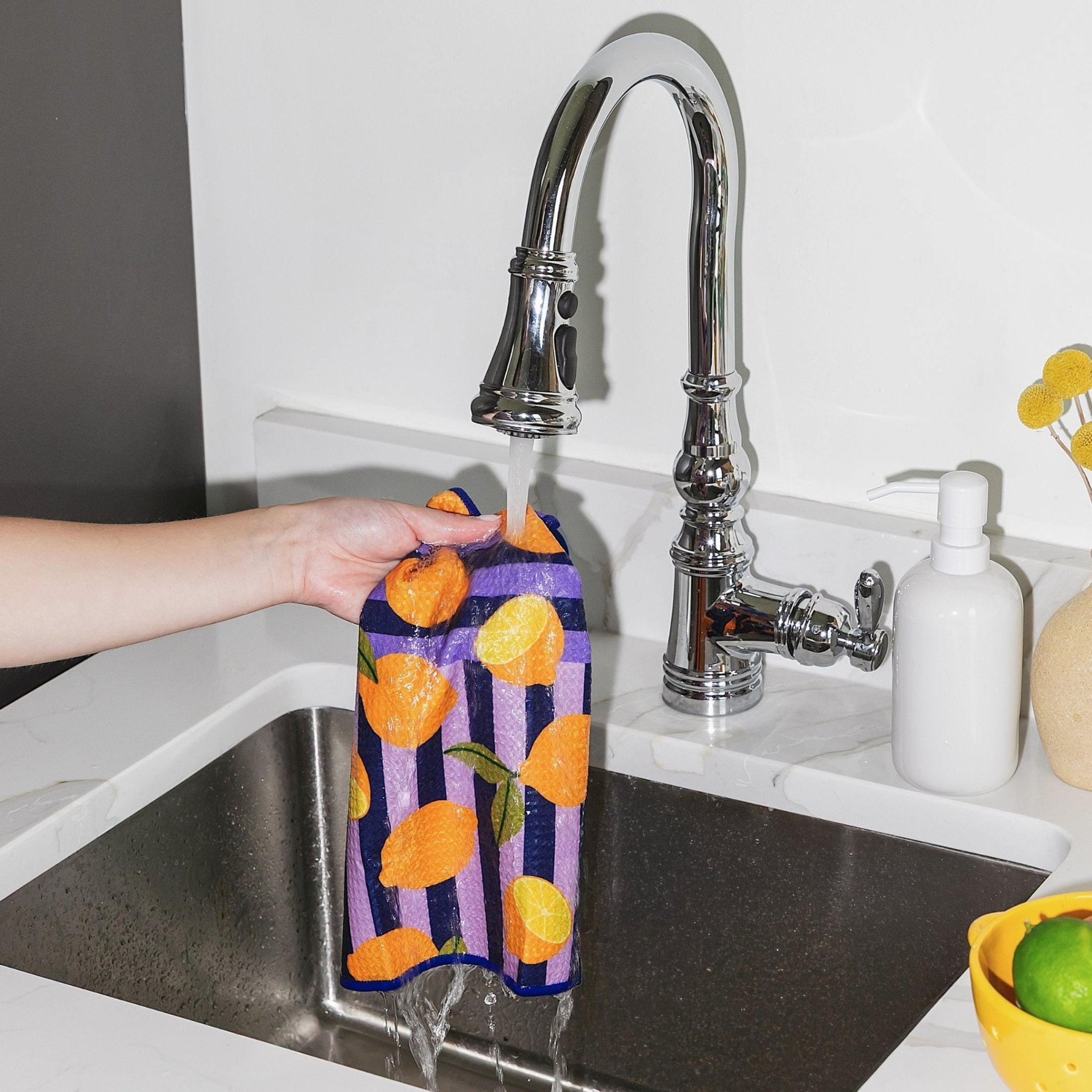 Chunky Deli product image of a person holding a colorful towel with a lemon pattern over a kitchen sink.