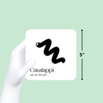 Gloved hand holds a black and white "Cavalappi" art card, showing its 5-inch size on a mint green background. 