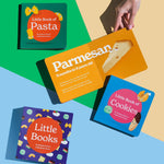 Product display featuring all elements of the "Little Books" box set: "Little Book of Pasta" (top), an open spread of "Little Book of Cheese" held by a hand and open to the Parmesan page, "Little Book of Cookies" (cover), and the complete box set (bottom)