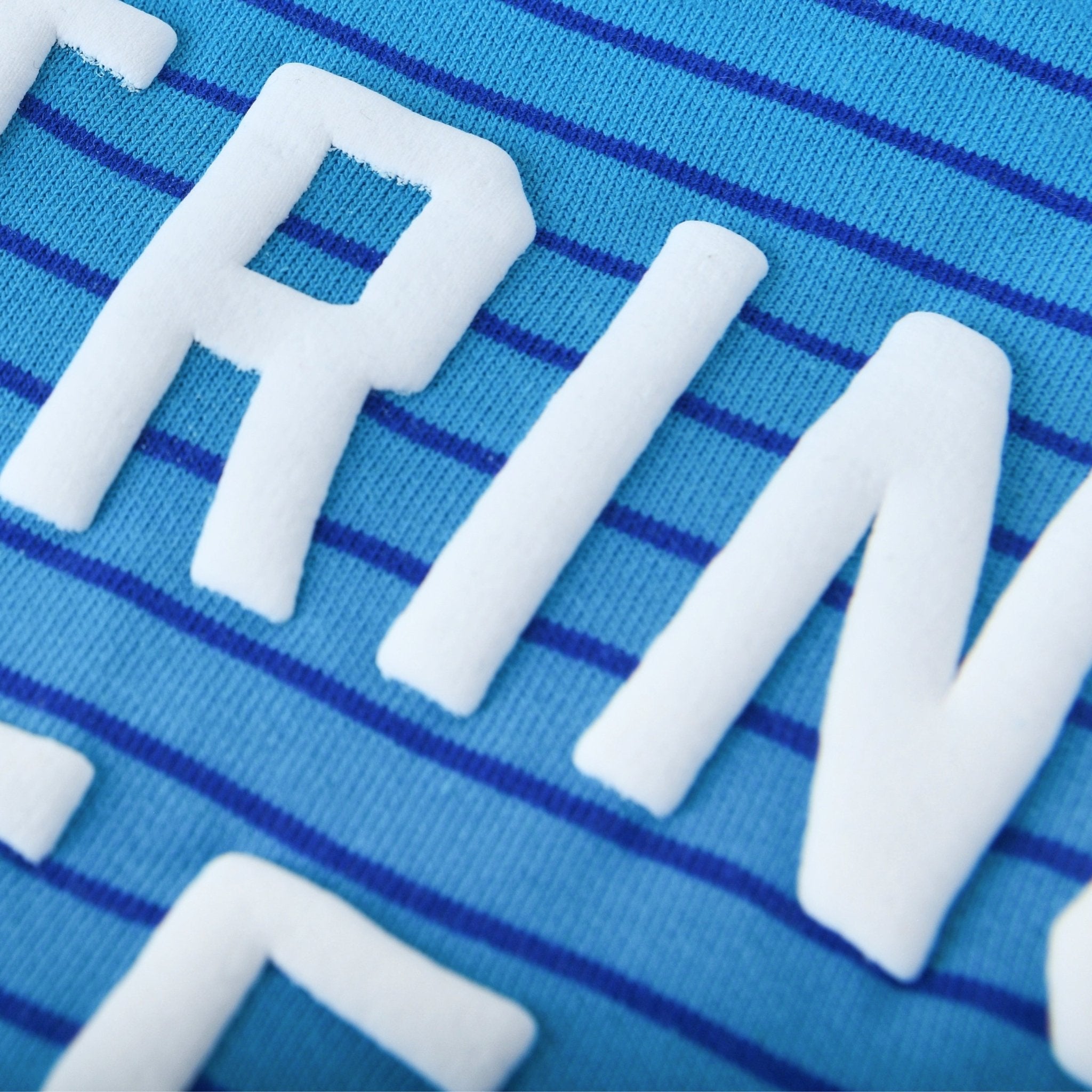 Close-up of the blue striped fabric of the String Cheese Kids Crewneck Sweater by Chunky Deli.
