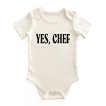 Chunky Deli baby bodysuit made from 100% cotton, short sleeve, beige/natural color with bold black text reading 'YES, CHEF' on the chest. Features envelope neckline and snap closure for easy changes.